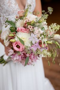 bride holding pastel flowers